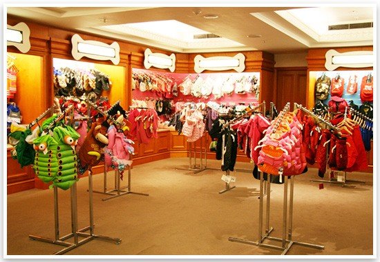 Luxury dog clothes and designer pet fashion on display racks inside the Harrods Pet Kingdom boutique.