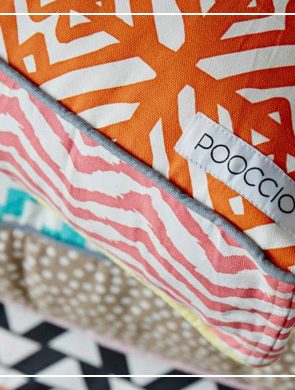 Stacked colorful, patterned dog cushions featuring the POOCCIO luxury dog brand label.