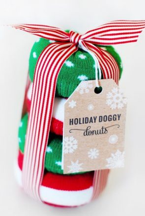 DIY festive holiday doggy donuts stacked and tied with a red striped ribbon and tag for a Christmas dog gift.