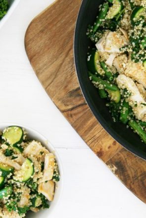 Healthy homemade dog food with chicken, quinoa, and zucchini in a skillet and bowl.
