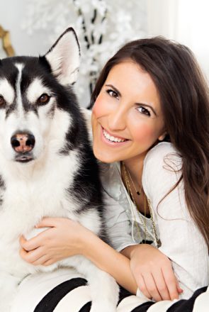 A smiling dog mum cuddling her Siberian Husky during a stylish, pet-friendly home tour.