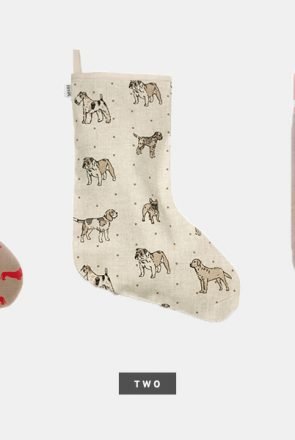 Cream linen Christmas stocking featuring dog breed illustrations, a stylish holiday trend for pet parents.