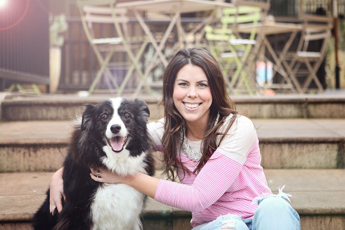 Pretty Fluffy founder Serena Faber-Nelson and her border collie dog on outdoor steps, celebrating new beginnings.