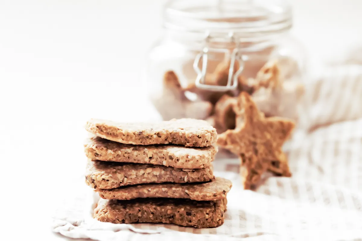 pile of homemade peanut butter and banana dog treats with jar in background
